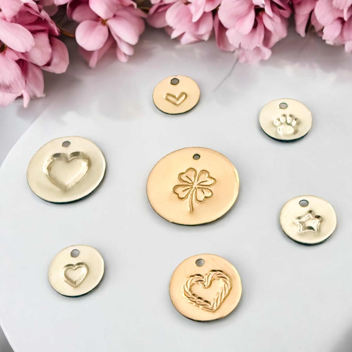 Stamped Story Necklace charms in gold and silver-tone metal, hand-stamped with heart, clover, paw and star designs